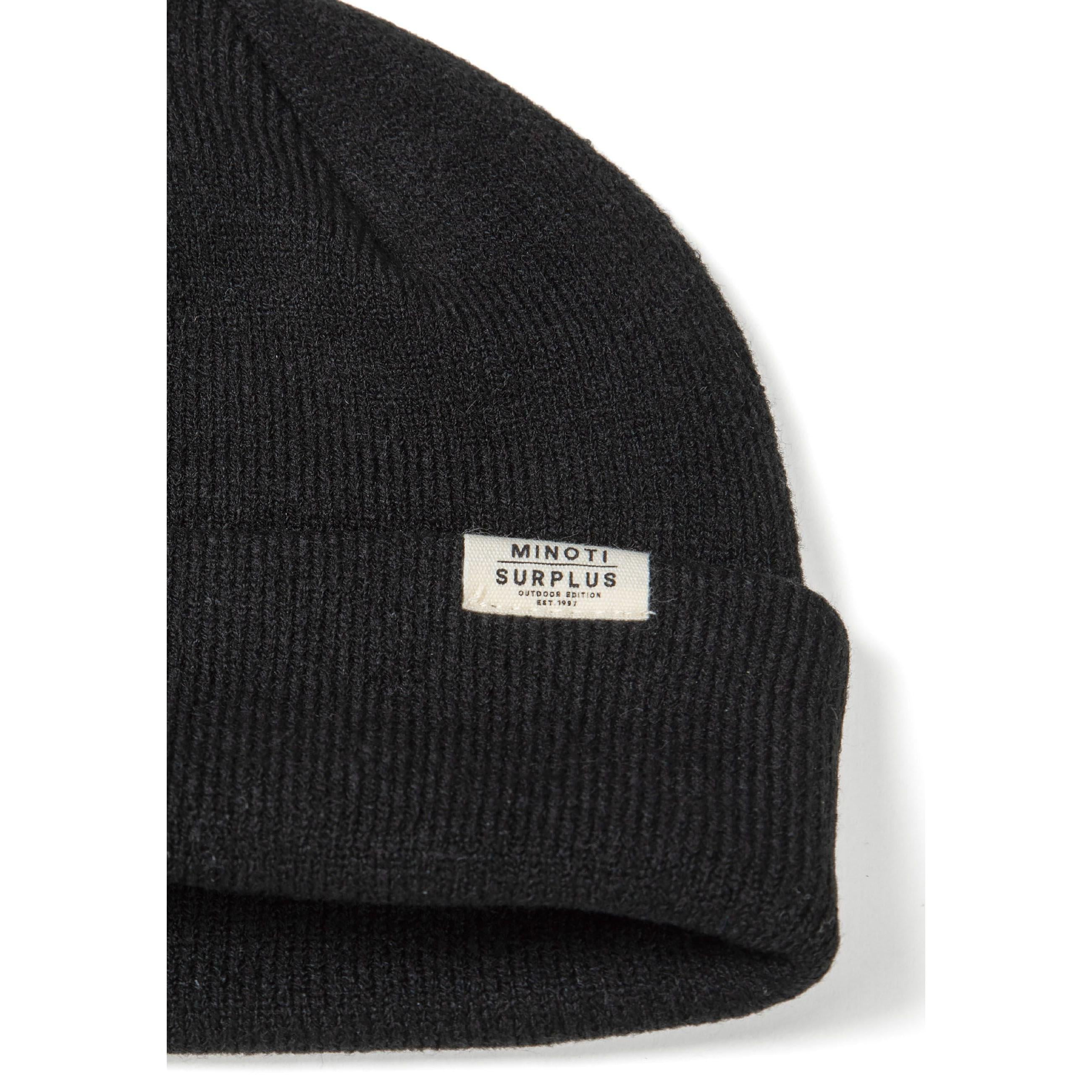Close-up detail of cream ribbed beanie showing Minoti Surplus woven label and soft knit texture on white background