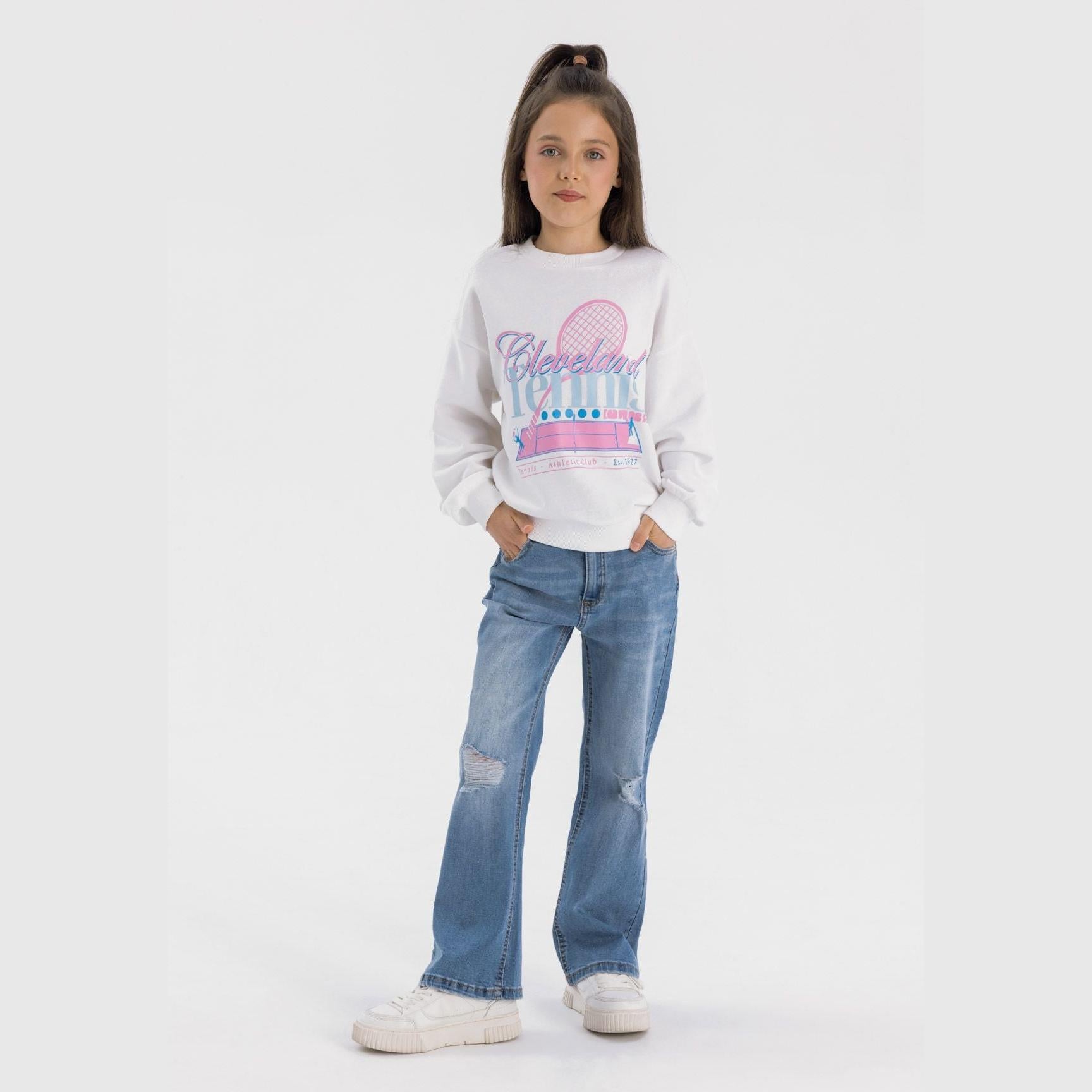 Young girl wearing navy denim flare jeans with white Cleveland sweatshirt, full body front view on white background