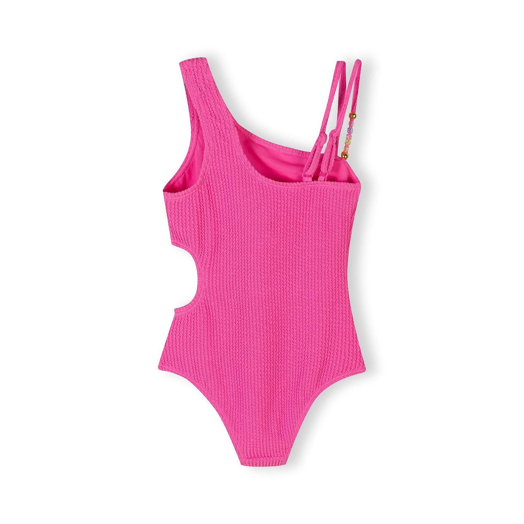 Back view of bright pink ribbed swimsuit showing asymmetrical design and beaded strap details on white background