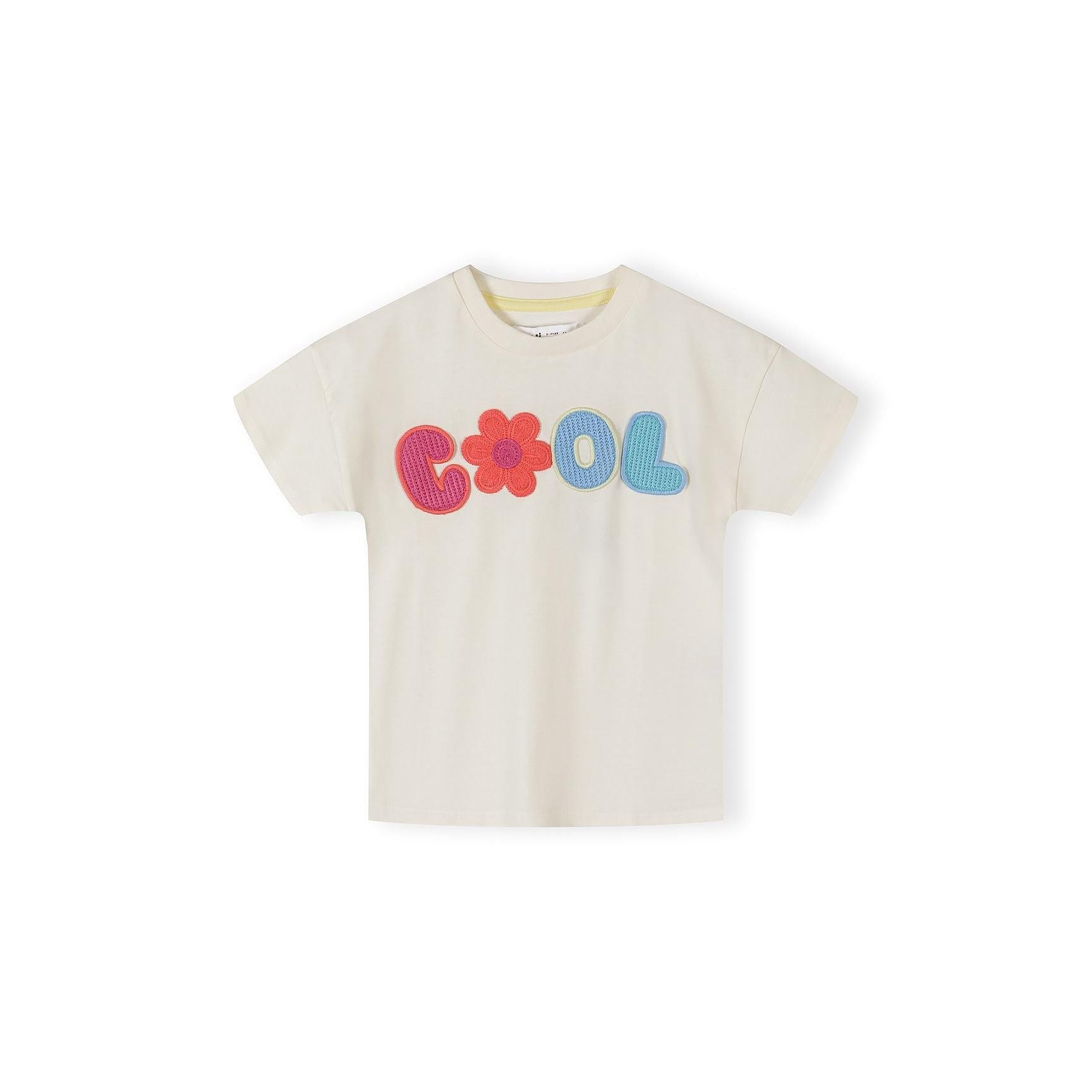 Off-white cotton t-shirt with colourful crochet 'COOL' appliqué featuring flower detail, displayed flat against white background