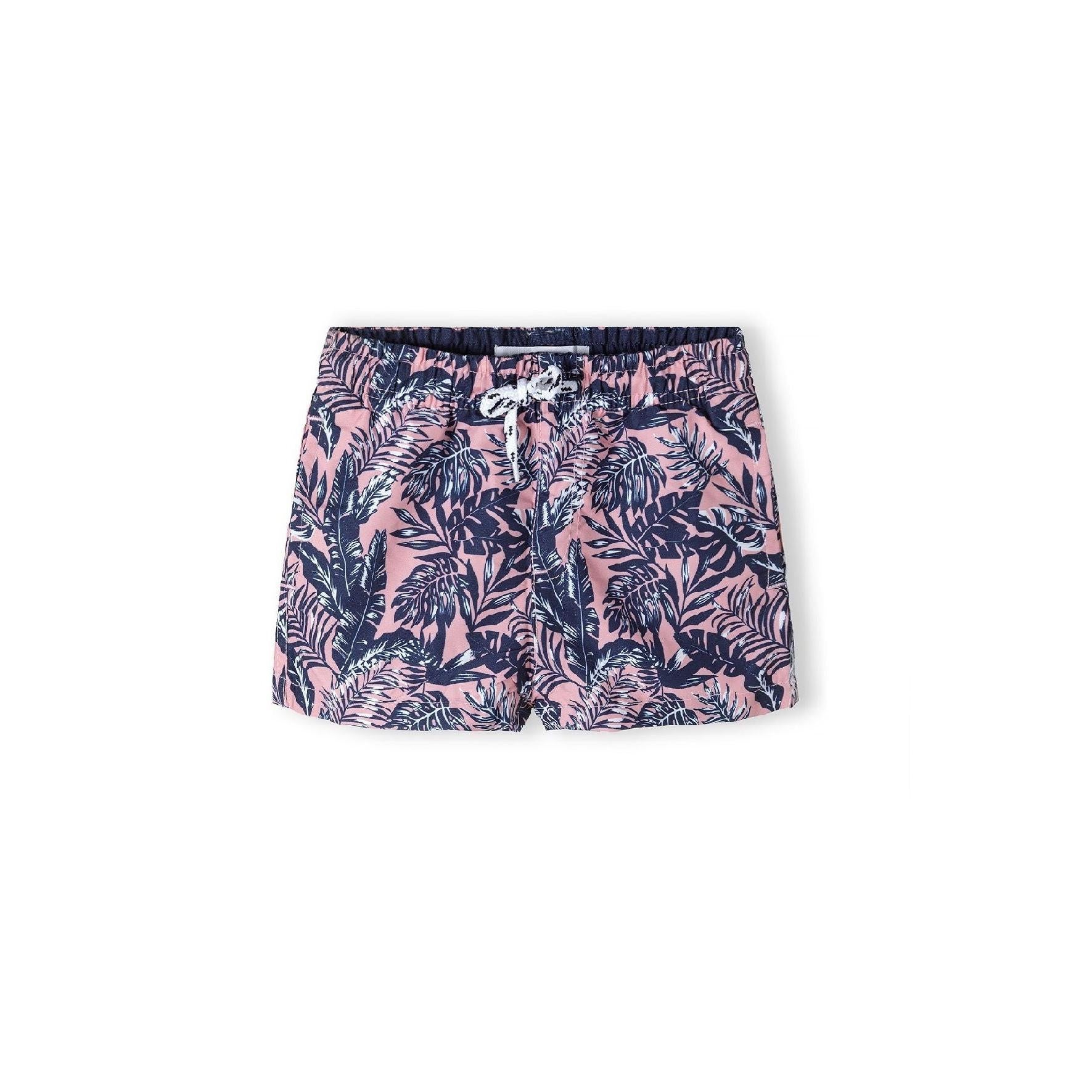Flat lay view of coral board shorts with navy tropical leaf print showing Minoti waistband label and drawstring detail