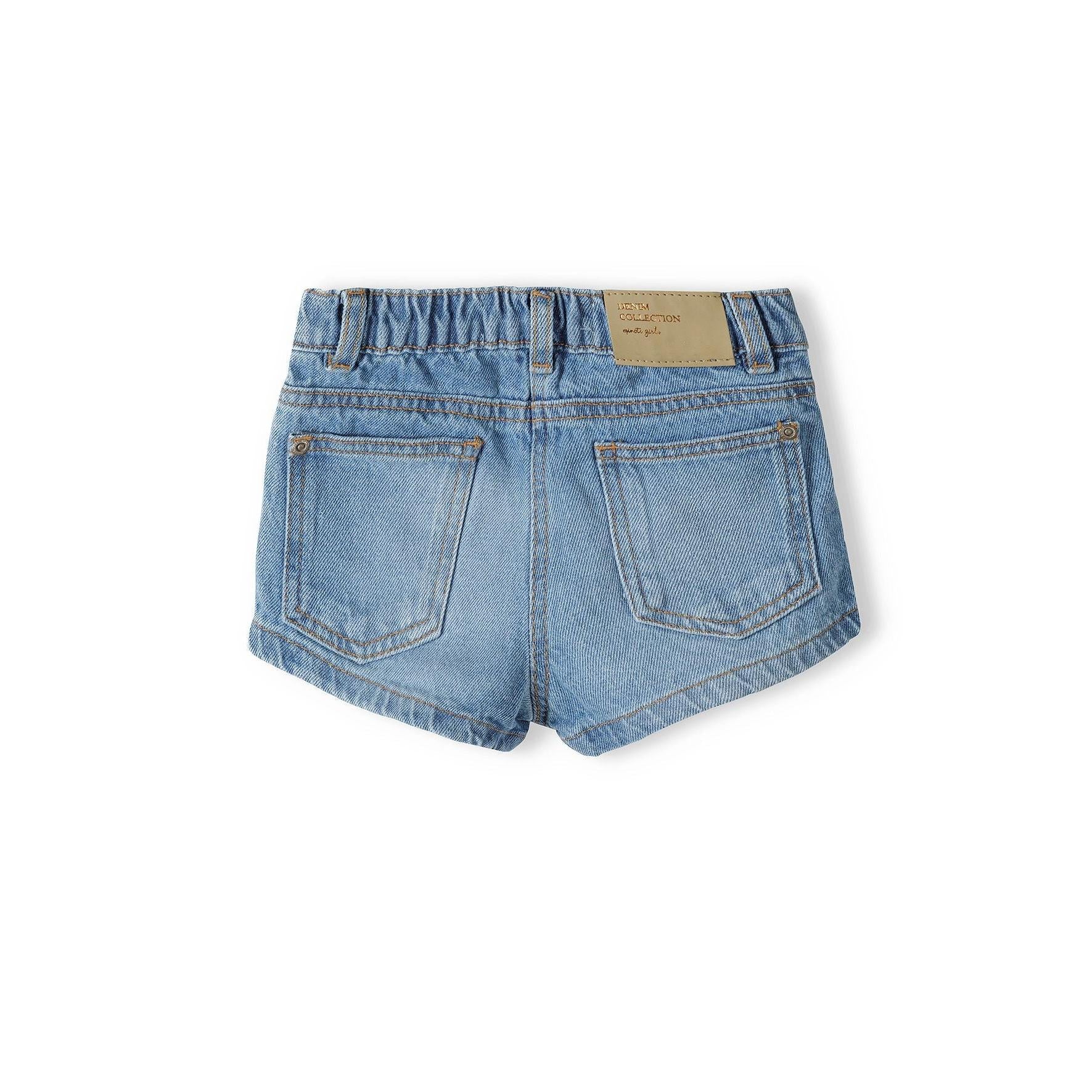 Back view of navy denim shorts on white background showing rear pockets, elastic waistband and beige brand label