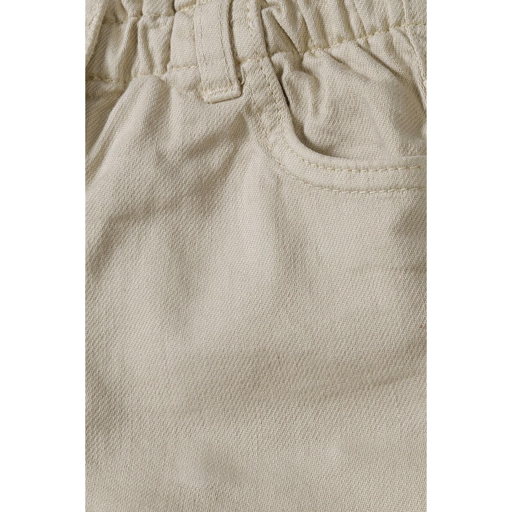 Close-up detail of grey twill shorts fabric texture and elasticated waistband construction