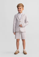 Smiling boy wearing a stone striped cotton blazer with matching shorts and casual shoes on white background