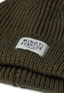Detail of khaki knitted rib hat with badge.