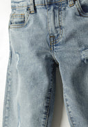 Boys straight jeans in light blue with ripped details, close-up view.