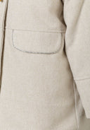 Detail of a girls' padded jacket in grey with a pocket and herringbone pattern.