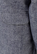 Detail of a girls padded jacket in navy with herringbone pattern.