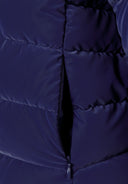 Detail of a navy padded jacket showing a zip pocket and quilted texture.