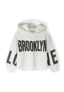 Hooded girls' sweatshirt in white with printed text, front view, features drop shoulder fit and kangaroo pocket.