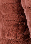 Detail of a brown faux fur jacket with structured collar and soft texture.