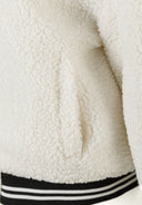 Detail of a cream borg baseball jacket with ribbed cuffs and hem.