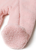 Detail of a light pink baby snowsuit with soft sherpa fabric and rounded foot.