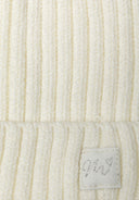 Close-up of a cream knitted rib beanie for babies, featuring a small lurex badge.