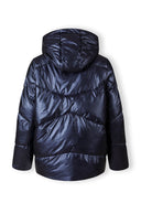 Back view of a women's navy quilted short hooded jacket with a zip and flap pockets.