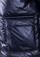 Detail of a navy quilted women's jacket featuring a flap pocket.