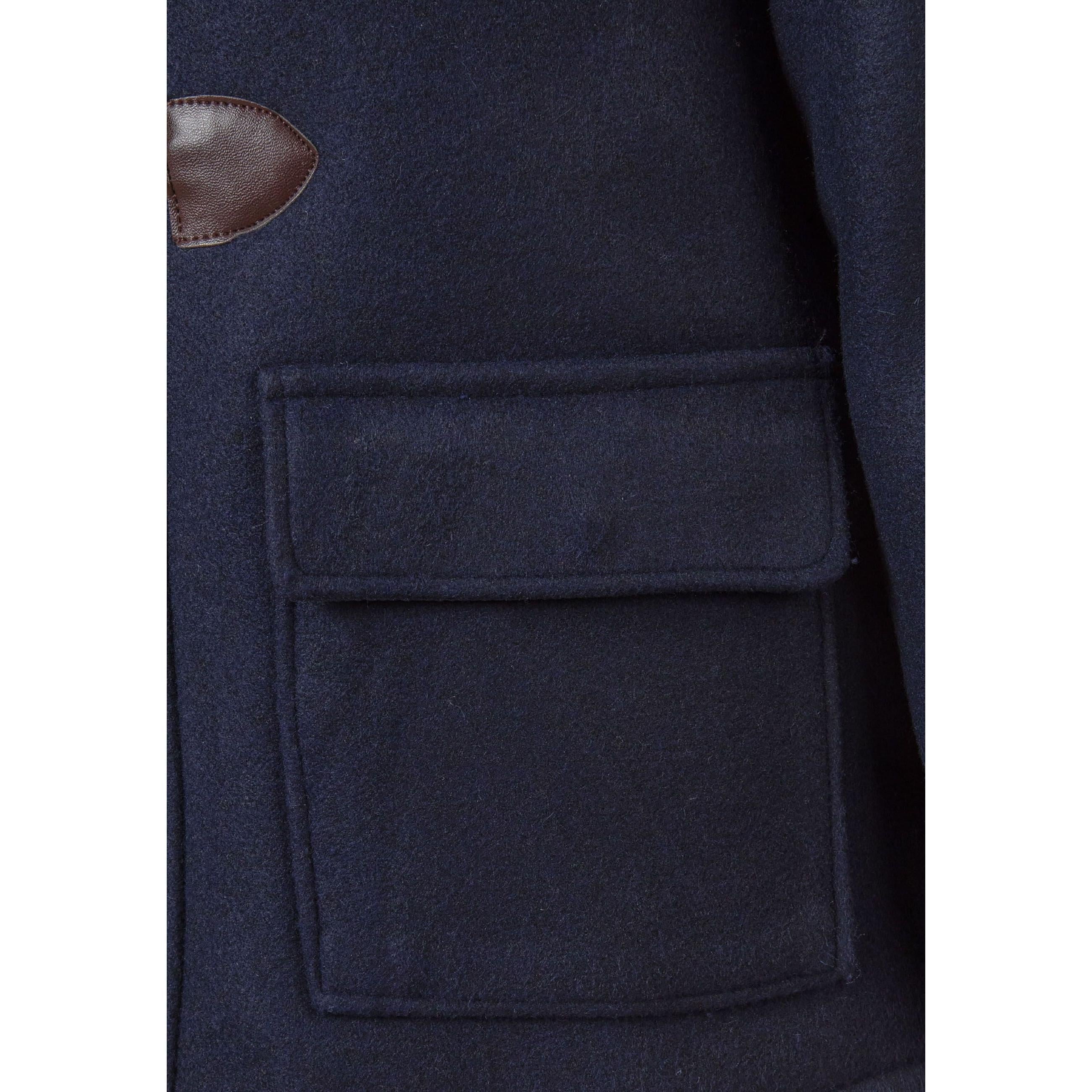 Close-up detail of navy duffle coat showing front patch pocket and toggle closure with brown leather-effect backing