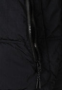 Detail of a black quilted boys jacket featuring a zip pocket.