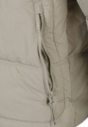 Detail of a boys quilted jacket showing a zip pocket and quilted texture.