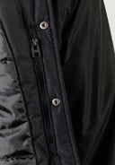 Detail of black men's baseball jacket with zip and snap closures.
