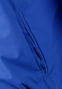 Detail of a cobalt blue men's baseball jacket showing a zippered pocket.