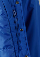 Detail of a cobalt blue men's baseball jacket featuring a zip pocket and snap button.