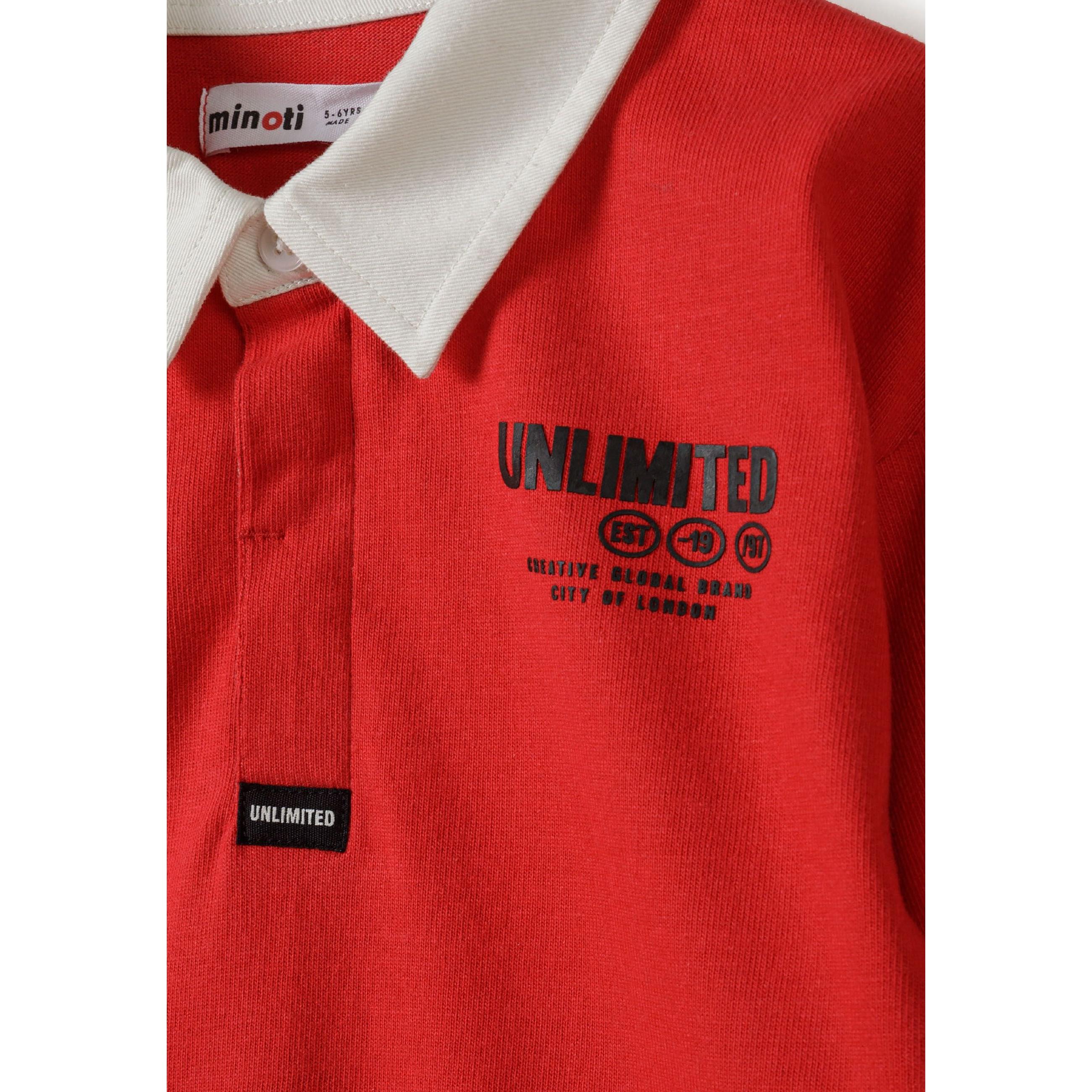 Close-up detail of red polo shirt showing white contrast collar, button placket, chest print with 'Unlimited' branding and fabric texture