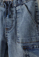 Detail of boys' denim jogger cargo jeans with elastic waistband and patch pockets.