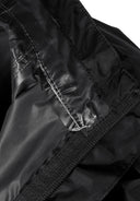 Detail of a black waterproof jacket showing the inner lining and velcro closure.