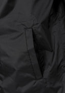 Detail of a black waterproof jacket showing a side pocket.