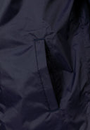 Detail of a navy waterproof jacket showing a side pocket.