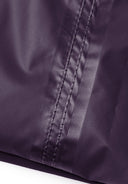 Detail of purple waterproof overpants with visible stitching.
