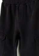 Detail of black girls fleece cargo joggers with elasticated waistband and side pockets.
