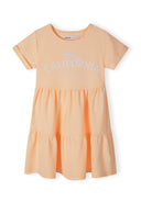 Girls short sleeve dress in bright orange with tiered hem and decorative print.