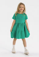 Girls short sleeve green fleece dress with tiered hem and decorative front print.
