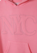 Close-up of a pink girls fleece hooded dress featuring a large NYC print and kangaroo pocket.