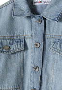 Close-up of a light blue cropped denim bomber jacket with button fastening and flap pockets.