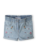 Girls denim shorts in light blue with paperbag waist and embroidered flowers, front view.