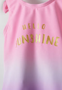 Detail of a girls' one-piece swimsuit in pink with gold text 'HELLO SUNSHINE'.