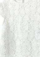Detail of a girls' white lace dress featuring intricate lace patterns on the bodice and sleeves.