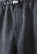 Detail of grey shorts with elastic waistband and side pocket.