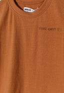 Detail of a boys' beige vest with round neckline and small print.