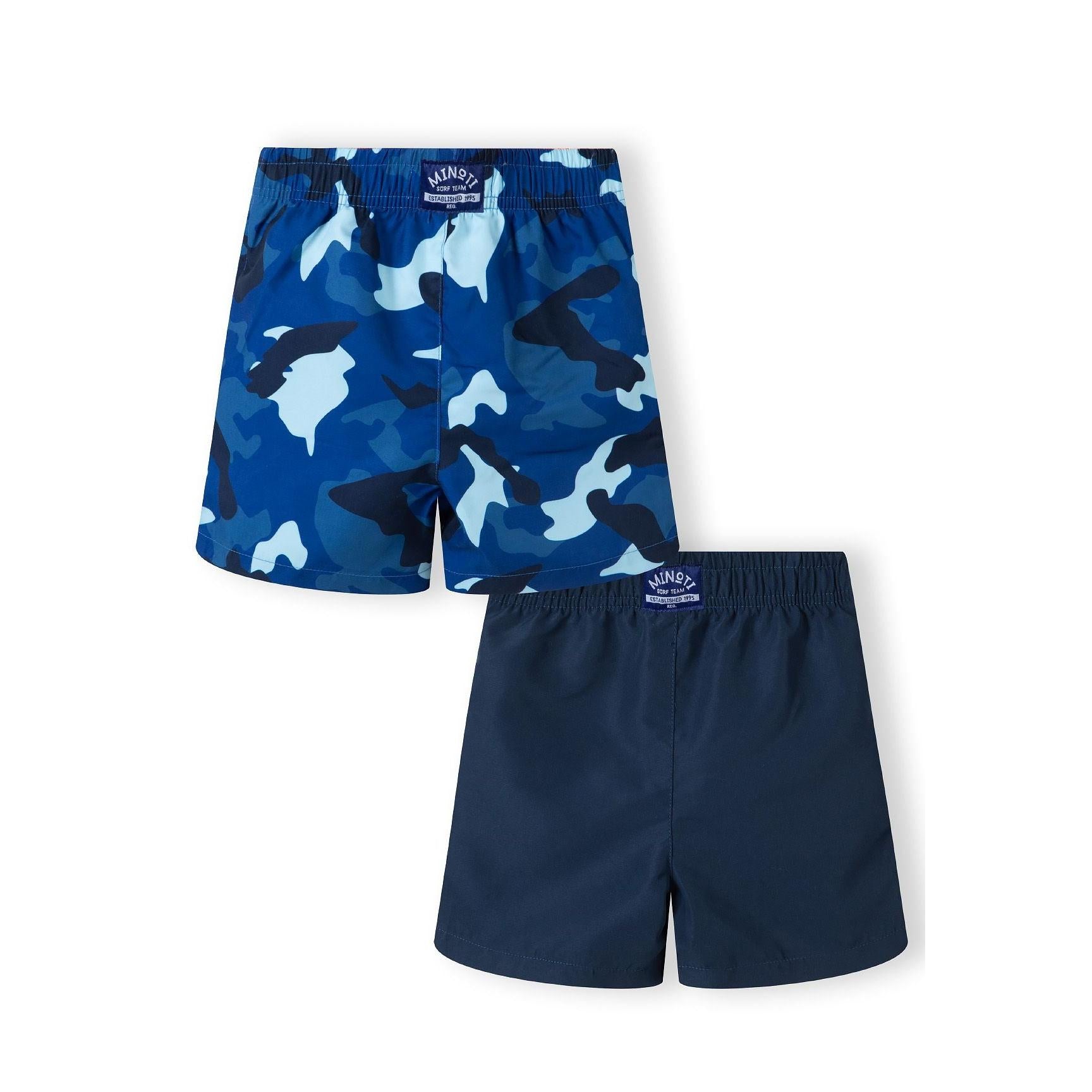 Back view of solid navy swim shorts with elastic waistband showing Minoti brand label on white background