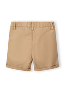 Detail of beige shorts with adjustable waistband and rolled cuffs.