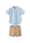 Boys grandad shirt in light blue with button front and beige shorts with side pockets.