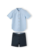 Boys grandad shirt in light blue with button fastening and navy shorts with adjustable waistband.