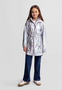 Girl wearing a shiny silver hooded jacket with drawstring waist and flap pockets, paired with dark jeans and sneakers