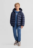 Young boy wearing a navy blue lightweight hooded jacket with zip fastening and side pockets, smiling confidently
