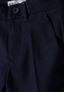 Detail of navy blue boys' formal trousers with a button and side pocket.