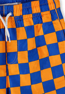 Detail of boys' quick dry swim shorts in orange and blue check pattern with elastic waistband.
